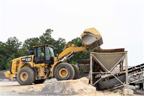 Rahns Concrete: A Rahns Concrete Caterpillar 966M loads a hopper with concrete sand at a portable ready-mix concrete plant. 
