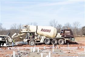 Rahns Concrete: A Rahns Concrete front discharge mixer truck feeds product into a pump truck for a pour. 