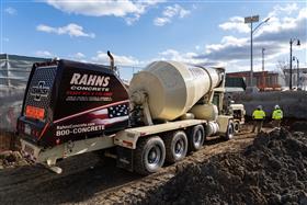 Rahns Concrete: A Rahns Concrete front discharge mixer truck feeds product into a pump for a pour. 
